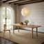 Rustic elegant dining room combining natural textures, timber furniture, woven seating and modern clean lines in a warm premium interior.