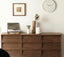 Placed against white wall with decorative items on top