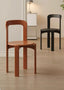 Terracotta and black minimalist wooden dining chairs on light wood floor