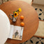 Round wooden dining table with amber finish