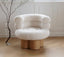 White boucle armchair with rounded cushions on wooden cylindrical base