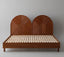 Wooden bed with woven headboard on a gray background