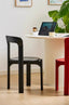 Terracotta and black minimalist wooden dining chairs on light wood floor