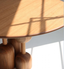 Round medium-toned wood dining table with sculptural base