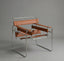 Modern chair with brown leather seat and backrest on a gray background