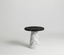 Marble-styled side table with black top on a white background