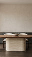 Luxury bespoke walnut and travertine dining table in a calm designer dining room