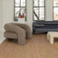 Gray curved armchair with cylindrical sides and plush upholstery