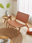 Terracotta leather woven lounge chair with wooden frame in sunlit room