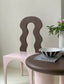 Design: Pastel pink Antoine Dining French Chair with a wavy wooden backrest and arch-inspired base.