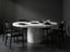 Orris Stone round white marble dining table with cylindrical pedestal base styled with black dining chairs