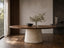 Serena Oval Walnut and Travertine Dining Table styled in a warm modern dining room with beige stone pedestal and walnut top.