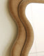 Full-length wooden mirror with wavy, undulating frame design